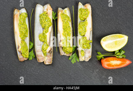 Les mactres navajas avec pesto de persil vert plaque en ardoise noire ona - Vue de dessus Banque D'Images