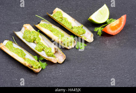 Les mactres navajas avec pesto de persil vert plaque en ardoise noire ona - Vue de dessus Banque D'Images