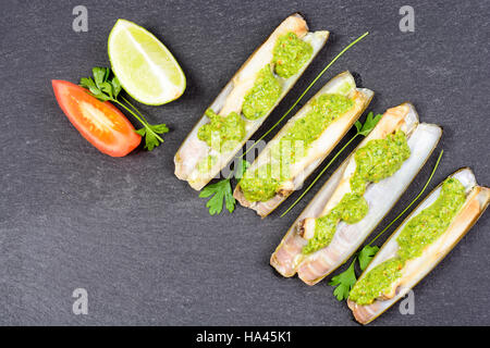 Les mactres navajas avec pesto de persil vert plaque en ardoise noire ona - Vue de dessus Banque D'Images