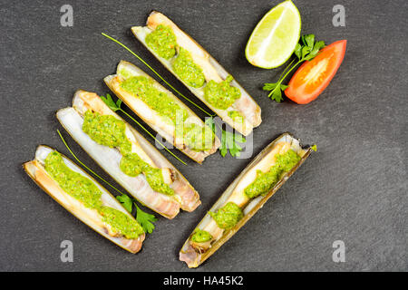 Les mactres navajas avec pesto de persil vert plaque en ardoise noire ona - Vue de dessus Banque D'Images