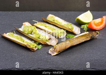 Les mactres navajas avec pesto de persil vert plaque en ardoise noire ona - Vue de dessus Banque D'Images