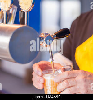 La bière au barman de servir un projet de la bière servant dans un restaurant ou un pub. Banque D'Images