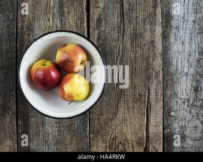 28 novembre 2016 - Trois pommes dans un bol émaillé de métal sur table en bois ancien patiné © Igor Golovniov/ZUMA/Alamy Fil Live News Banque D'Images