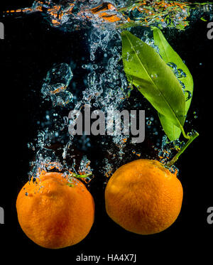 Orange et mandarine dans l'eau avec des bulles d'air. Banque D'Images