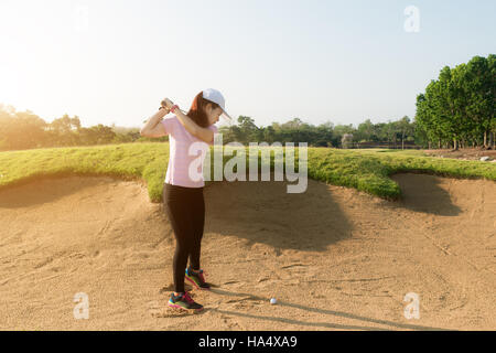 Femme Asiatique player hitting golf balle de golf hors de fosse de sable. Golf sport concept. Banque D'Images