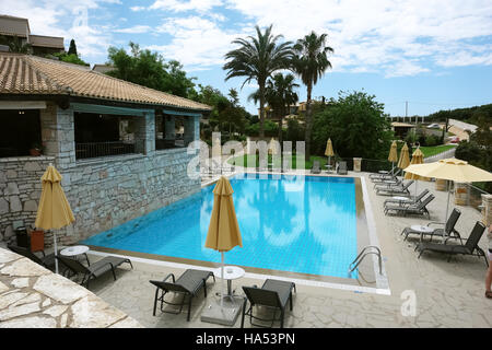 Blue piscine et parasols sur le terrain de bungalow sur la côte de la mer Ionienne, en Grèce. Banque D'Images