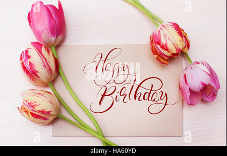 Bouquet de tulipes rouges sur fond blanc avec texte Joyeux anniversaire. Lettrage calligraphie Banque D'Images