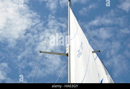 Un yacht de voile contre un ciel bleu avec des nuages blancs Banque D'Images