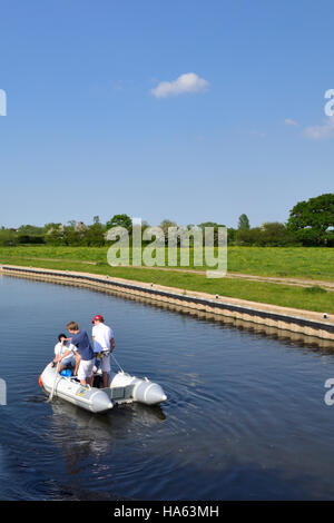 Trois adolescents s'amusant dans un esquif en caoutchouc sur le Trent & Mersey Canal près de Alrewas. Banque D'Images