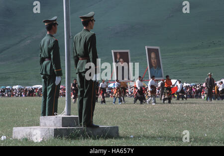 Légende : Yushu, Quinghai, Chine - juillet 2002. Des soldats chinois regarder comme Tibétain de souche Khampa garçons portent des affiches de Mao Ze Dong à l'ouverture Banque D'Images