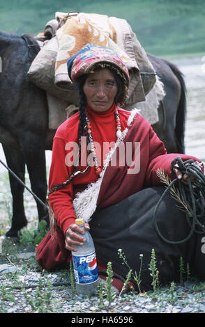 Légende : Axu, Sichuan, Chine - 19 août 2003. Un nomade Khampa avec son cheval et une bouteille de Pepsi, dans Axu, une province éloignée de l'ancien royaume tibétain de Banque D'Images