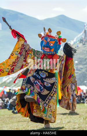 Un moine, vêtu comme un dieu, exécute une danse du temple au Festival Yushu dans le Qinghai. Banque D'Images