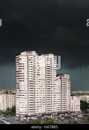 Immeuble sous le noir des nuages orageux Banque D'Images