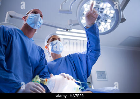 Chirurgiens en interaction les uns avec les autres dans la salle d'opération Banque D'Images