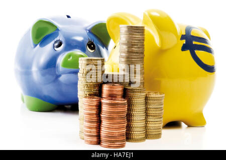 Pile de pièces en face de Piggy Banks Banque D'Images