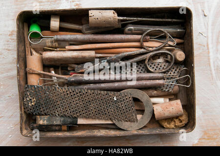 Outils de style Vintage Retro dans une boîte à outils d'étain sur une table de l'atelier Banque D'Images