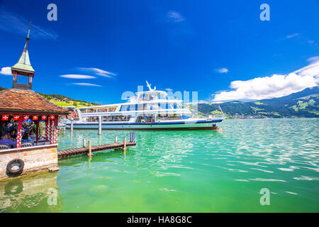 Superbe vue panoramique de navire d'excursion traditionnelle célèbre sur le lac de Zoug sur une journée ensoleillée avec ciel bleu et Alpes Suisses Banque D'Images