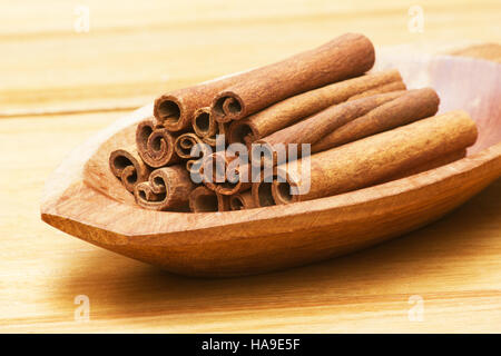 Cannelle (Cinnamomum verum) bâtons dans un bol en bois Banque D'Images