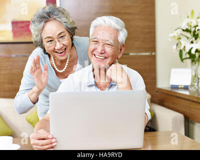 Senior asian couple dire bonjour lors d'un chat vidéo. Banque D'Images