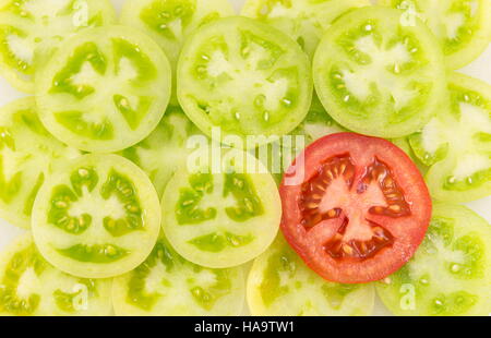 Les tomates vertes coupées en 0501 et cercles à côté d'une tranche de tomate rouge Banque D'Images