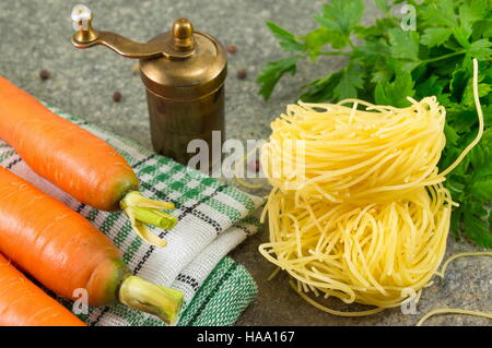 Balle de nouilles non cuites avec des carottes et du persil Banque D'Images