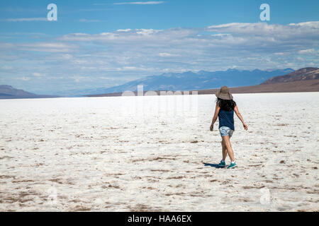 Femme marche au milieu de la Badwater Basin, Death Valley National Park, California, USA Banque D'Images