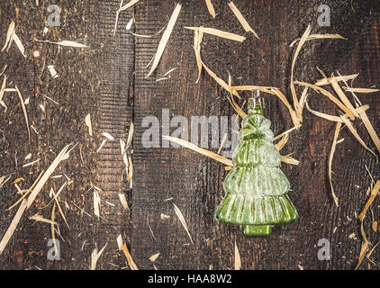 Arbre de Noël en verre-jouet dans la forme de l'épinette de neige sur un fond sombre. rustique en bois Banque D'Images