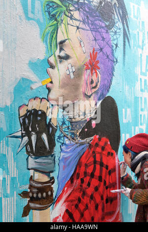 Artiste - Lora Zombie - travaillant sur le graffiti dans le Hanbury Street, près de Brick Lane Banque D'Images