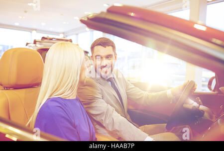 Heureux couple qui achète en voiture ou au salon de l'auto Banque D'Images