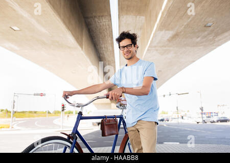 Homme hipster avec vélo pignon fixe sous le pont Banque D'Images