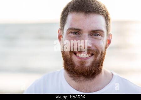 Visage de happy smiling young man on beach Banque D'Images