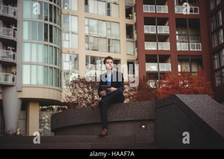 Businessman with digital tablet assis dans les locaux à usage de bureaux Banque D'Images