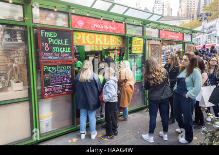 Des dizaines de visiteurs à l'Bryant Park Maison de vacances jusqu'à la ligne du marché Pickle moi Pete kiosque pour satisfaire eux-mêmes sur les commandes de fried pickles, vu le samedi 19 novembre, 2016. (© Richard B. Levine) Banque D'Images