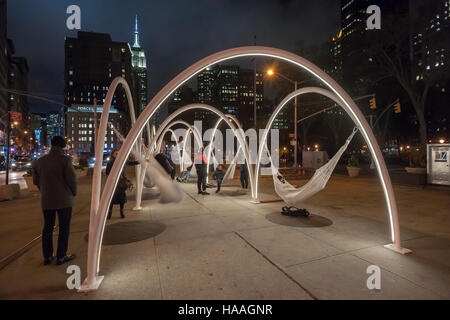 Les visiteurs de flatiron Plaza à New York le mardi, novembre 22, 2016 interagir avec 'ciel flatiron ligne' créé par société d'architectes lot. l'installation de Noël est l'élément central de la 23e rue du Flatiron partenariat de programmation. les dix arcs lumineux avec des hamacs suspendus sous impliquer les visiteurs de se détendre et de contempler les merveilles architecturales du quartier, en particulier le Flatiron building. (© richard b. levine) Banque D'Images