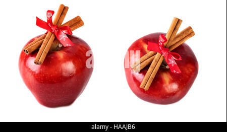 Pommes rouges lumineuses décorées de Noël avec des bâtons de cannelle sur fond blanc Banque D'Images