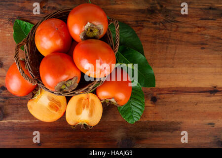 Fruits en kaki panier en osier. Vue d'en haut. Banque D'Images