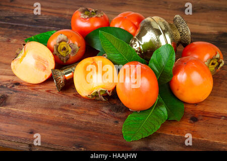 Le kaki kaki avec fruits vintage vase en laiton. Persan oriental est toujours la vie. Banque D'Images