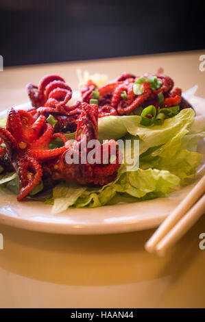 Bébé barbecue asiatique épicée octopus sur lit de laitue Banque D'Images