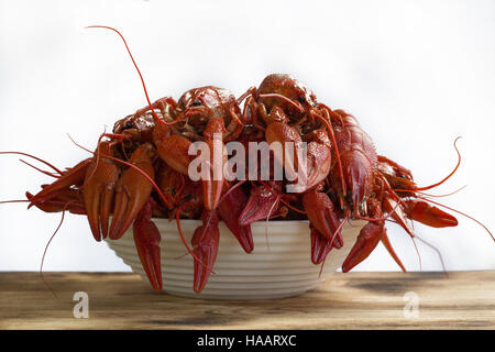 Assiette de langoustines bouillies avec pinces sur table en bois isolé sur fond blanc Banque D'Images