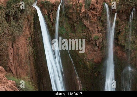 Couleur rouge de la montagne avec plusieurs lignes de cascades. Divers arbustes et arbres croissant sur la montagne. Cascades Ouzoud, Maroc. Banque D'Images