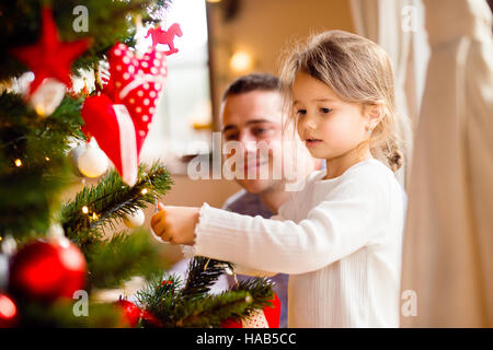 Jeune père avec daugter decorating Christmas Tree ensemble. Banque D'Images