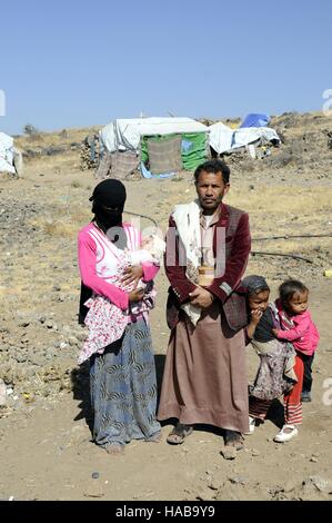 Sanaa, Yémen. 28 Nov, 2016. Une famille posent pour une photo à al-Riqah camp temporaire de personnes déplacées, à 35 km de Sanaa, capitale du Yémen, après qu'ils ont fui leur maison à cause des batailles, les conflits et les frappes aériennes, le 28 novembre 2016. La guerre civile, des combats au sol et de frappes aériennes ont déjà tué plus de 10 000 personnes, dont la moitié sont des civils, blessé plus de 35 000 autres personnes et déplacé plus de trois millions, selon les agences humanitaires. © Mohammed Mohammed/Xinhua/Alamy Live News Banque D'Images