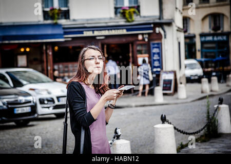 Jeune femme perdue holding plan de la ville, Paris, France Banque D'Images