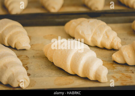 Des croissants congelés sur papier cuisson prêts à être cuisinés Banque D'Images