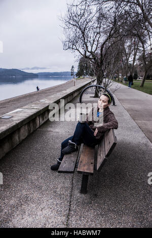 Woman relaxing on park bench. Banque D'Images