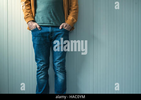 Tall méconnaissable en jeans casual man posing, mur comme copy space Banque D'Images