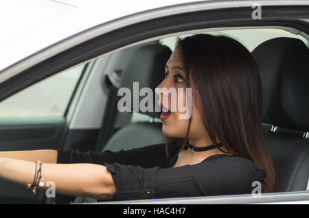 Libre de jeune femme assise dans la voiture avec l'interaction surpris, comme vu de l'extérieur, fenêtre pilotes concept pilote féminine Banque D'Images