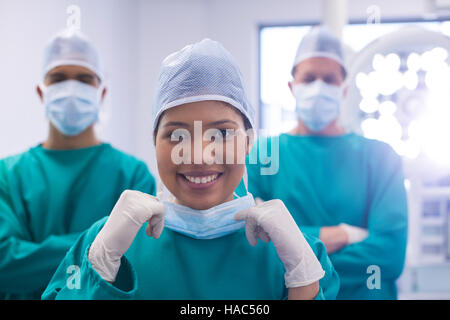 Équipe de chirurgiens portant un masque chirurgical en salle d'opération Banque D'Images