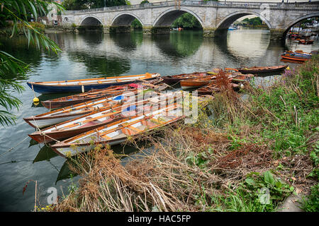 Location de barques traditionnelles amarrées à la rive de la Tamise à Londres avec Richmond Richmond Bridge en arrière-plan Banque D'Images