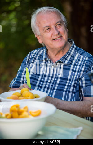 Senior avec fruits abricots dans un bol Banque D'Images